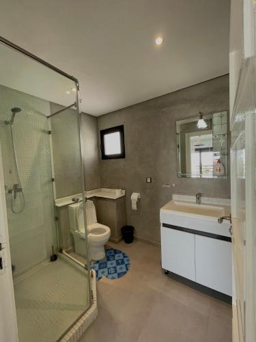 a bathroom with a shower and a toilet and a sink at VILLA EVASION Aglou Center in Zaouia Sidi Ouaggag