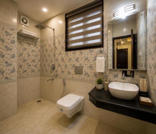 a bathroom with a toilet and a sink and a mirror at The Valley View in Srinagar
