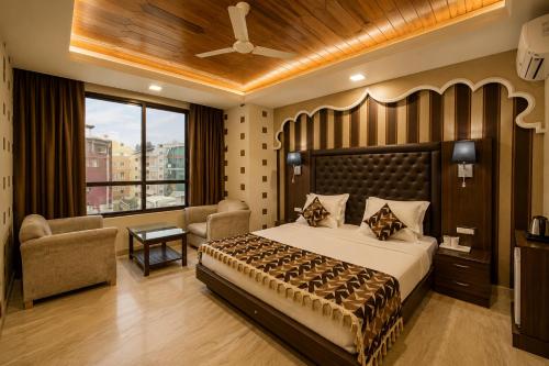 a bedroom with a bed and a chair and a window at The Valley View in Srinagar