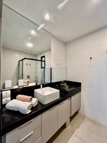 a bathroom with a sink and a mirror at Flat Elegante, Confortável e Com Uma Bela Vista in Campo Grande