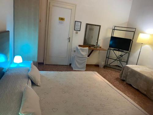a bedroom with a bed and a table and a mirror at Travellers Lodge Bed & Rooms in Treviso