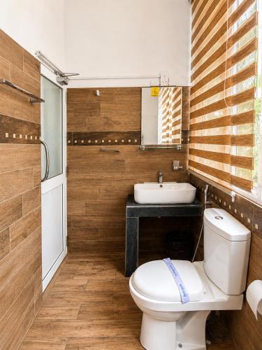 a bathroom with a toilet and a sink at Mounts Edge Regency in Mahiyangana