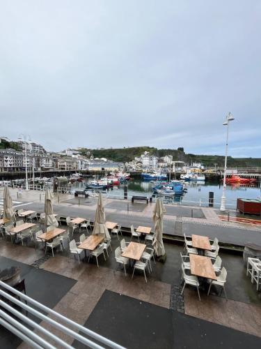 a patio with tables and chairs and a marina at La Casina del Puerto in Luarca