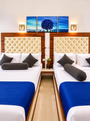 two beds in a room with blue and white at Mounts Edge Regency in Mahiyangana