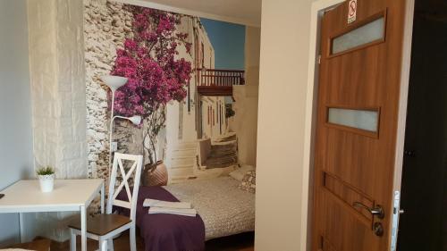 オジシュにあるKormoranのベッド、テーブル、ドアが備わる小さな客室です。