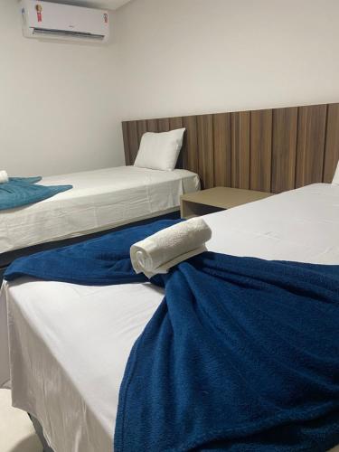 a room with two beds with blue and white sheets at Ondi Cosmopolitan in Palmas