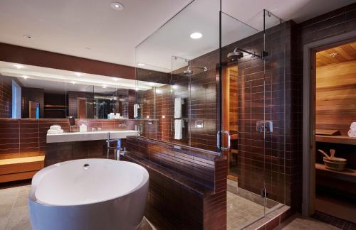 a bathroom with a toilet and a sink and a shower at Loews Chicago O'Hare Hotel in Rosemont