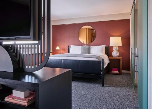 a hotel room with a bed and a mirror at Loews Chicago O'Hare Hotel in Rosemont