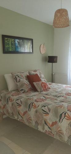 a bed with a comforter and pillows on it at Chambre d'hôtes Thé ou Café in Auray