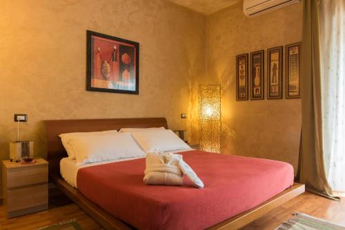 a bedroom with a bed with a red blanket at Villa Morgana Resort and Spa in Torre Faro
