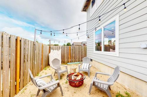 a patio with chairs and a fire pit and a fence at Dory Pointe Dream in Pacific City