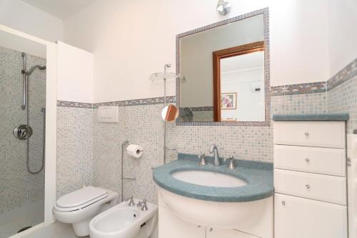 a bathroom with a sink and a toilet and a mirror at Limoneto by Espresso Rentals in Massa Lubrense