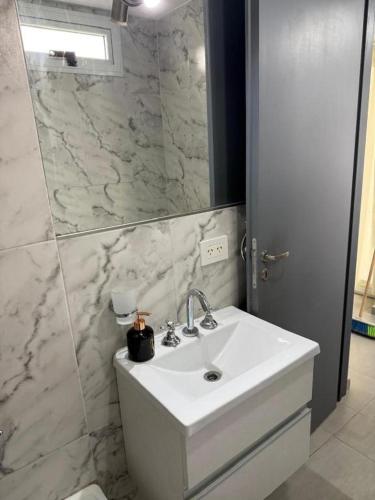 a white bathroom with a sink and a mirror at Sunny Stay Ezeiza in Ezeiza