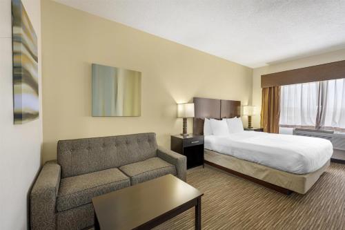 a hotel room with a bed and a couch at Best Western Plus the Four Corners Inn in Farmington