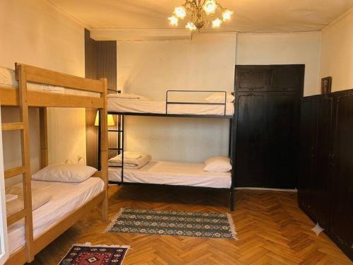 a room with three bunk beds and a chandelier at Vintageshvili hostel and guest house in Tbilisi City