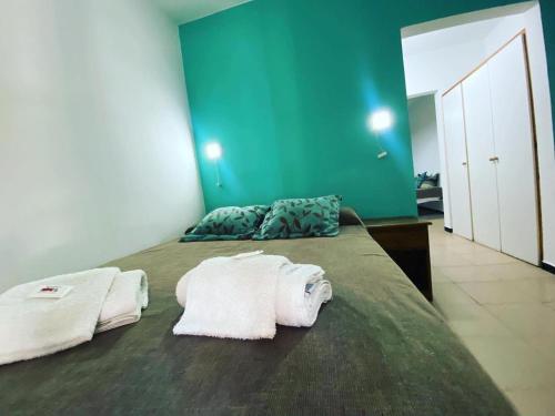 a bedroom with a bed with towels on it at Apart Hotel RioSol - Monoambientes in Concepción del Uruguay