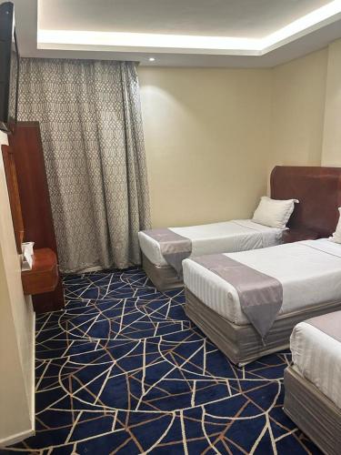 a hotel room with two beds and a carpet at فندق كرمك اجياد السد in Ajyad