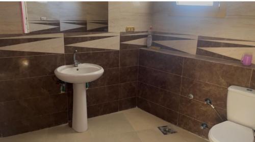 a bathroom with a sink and a toilet at فيلا بسين خاص in Dawwār Abū Maḩrūs