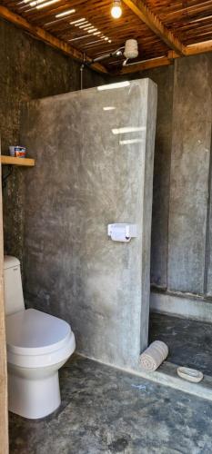 a bathroom with a toilet in a concrete wall at Wood & Net in Iringa