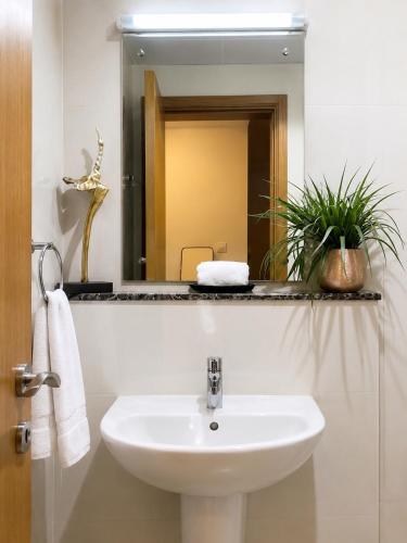 a bathroom with a sink and a mirror at Travellers Deluxe Apartment in Muscat