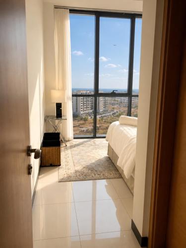 a bedroom with a bed and a large window at Travellers Deluxe Apartment in Muscat