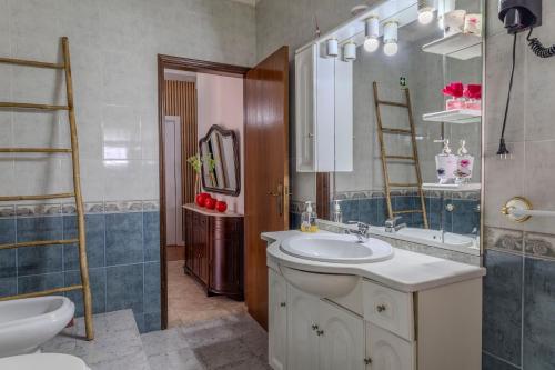 a bathroom with a sink and a toilet and a mirror at Canto Celeste in Alcobaça