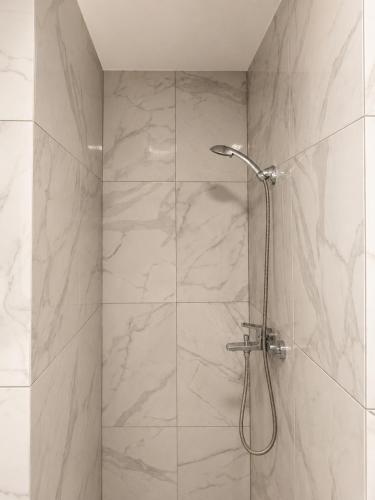 a bathroom with a shower with a glass door at Mis apartamentai in Mažeikiai