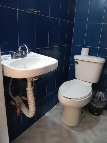 a bathroom with a toilet and a sink at Hotel Bora Bora Acapulco in Acapulco