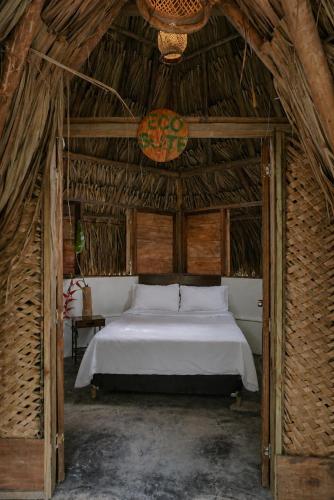 a bedroom with a bed in a straw hut at Rio Elemento Minca in Santa Marta