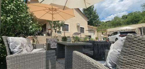 a patio with a table with an umbrella and chairs at Haus Natura in Jurdani