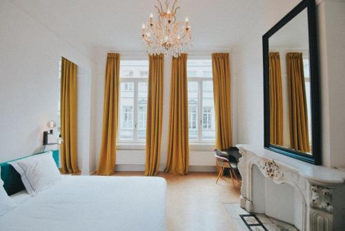 a bedroom with a bed and a mirror and a chandelier at Paulus41 in Antwerp