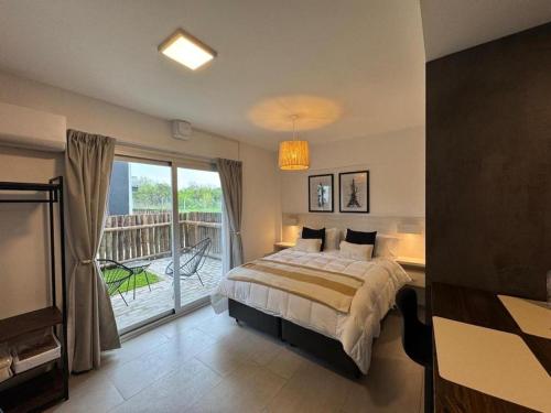 a bedroom with a bed and a balcony at Sunny Stay Ezeiza in Ezeiza