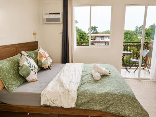 a bedroom with a bed with two stuffed animals on it at Spacious Studio w Pool, Gym, Smart Lock, Netflix in Puerto Princesa City