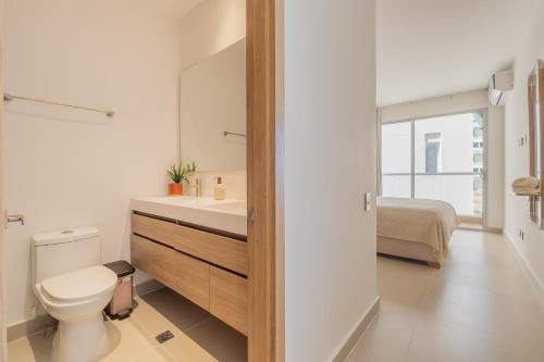 a bathroom with a toilet and a sink and a bed at BaiaKristal-Kabo3-3A in Cartagena de Indias