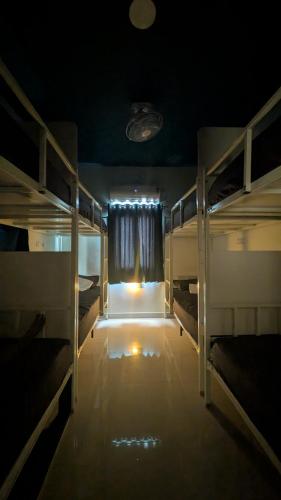 a room with three bunk beds and a window at Thuyil Inn Koodal in Madurai