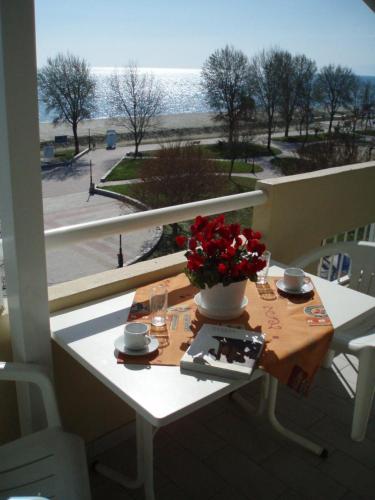 stół z wazą kwiatów na balkonie w obiekcie Giorgos Apartments Sea View w mieście Olympiakí Aktí