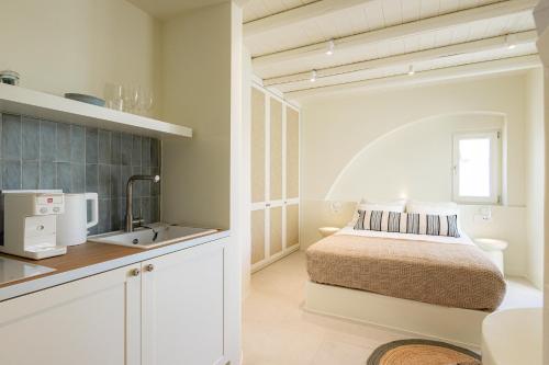 a small bedroom with a bed and a sink at Naxia Gaia Suites in Agia Anna Naxos