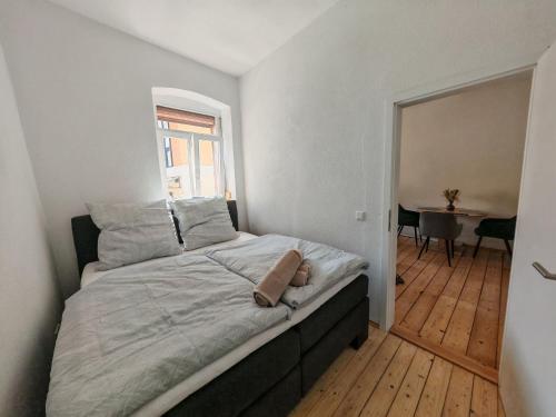 a bedroom with a bed with a window and a table at Gemütliche Stadtwohnung im Zentrum in Weinheim