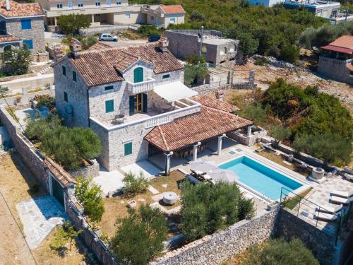 an aerial view of a stone house with a swimming pool at Villa Rustica - Veslo in Begovići