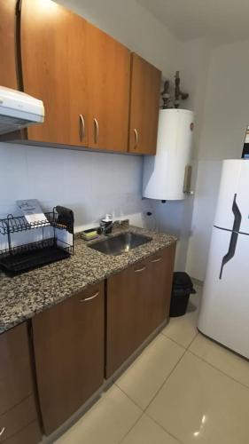 a kitchen with a sink and a refrigerator at Apart Plaza Escobar in Belén de Escobar