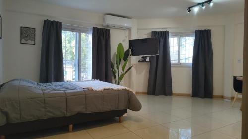 a bedroom with a bed and a flat screen tv at Apart Plaza Escobar in Belén de Escobar
