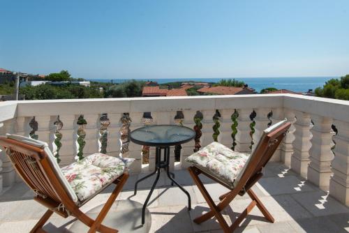 a table and two chairs on a balcony with the ocean at Villa Rustica - Veslo in Begovići