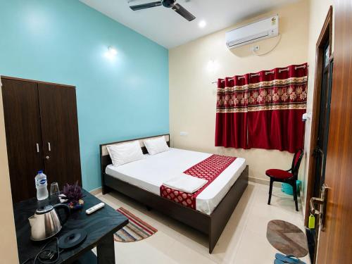 a bedroom with a bed and a desk in a room at Hotel Vindhwasni Palace in Sītāmarhi