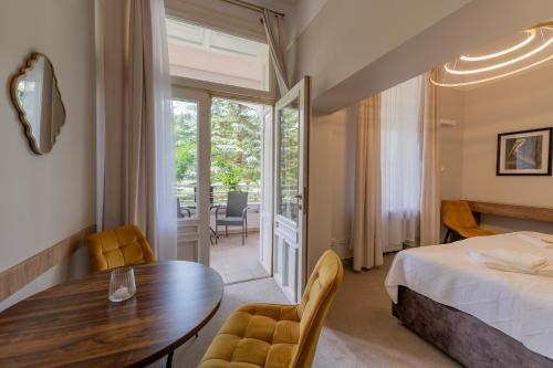 a bedroom with a bed and a table and chairs at Rezydencja Arabeska in Lądek-Zdrój