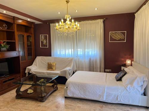 a bedroom with a bed and a chandelier at Apartamento en playa arenal de Burriana in Burriana