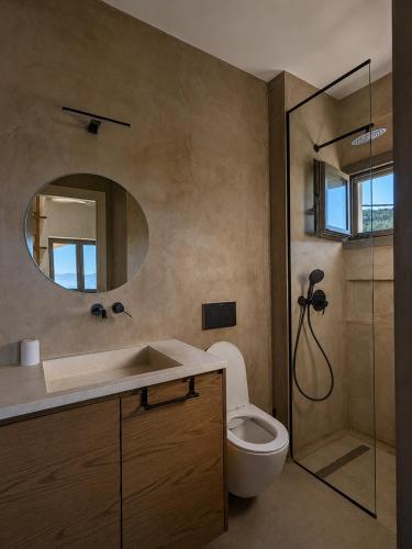 a bathroom with a toilet and a sink and a mirror at Trigono Suites - Karat in Politika