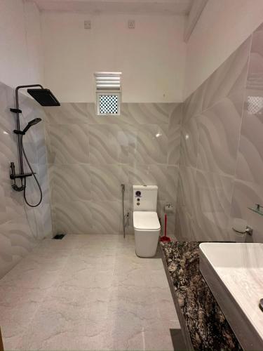 a bathroom with a toilet and a sink at Cinnamon Ridge Unawatuna in Unawatuna