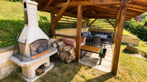an outdoor oven with a table and chairs under a pavilion at Sluneční stráň - dům pro 9 osob in Dolni Dvur