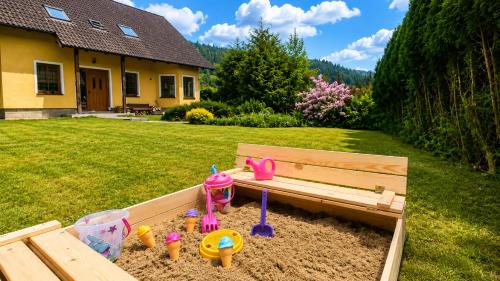 a sandbox with a bench in a yard at Sluneční stráň - dům pro 9 osob in Dolni Dvur
