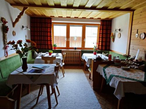 ein Zimmer mit Tischen und Stühlen und ein Zimmer mit Fenstern in der Unterkunft Haus Christina in Trins